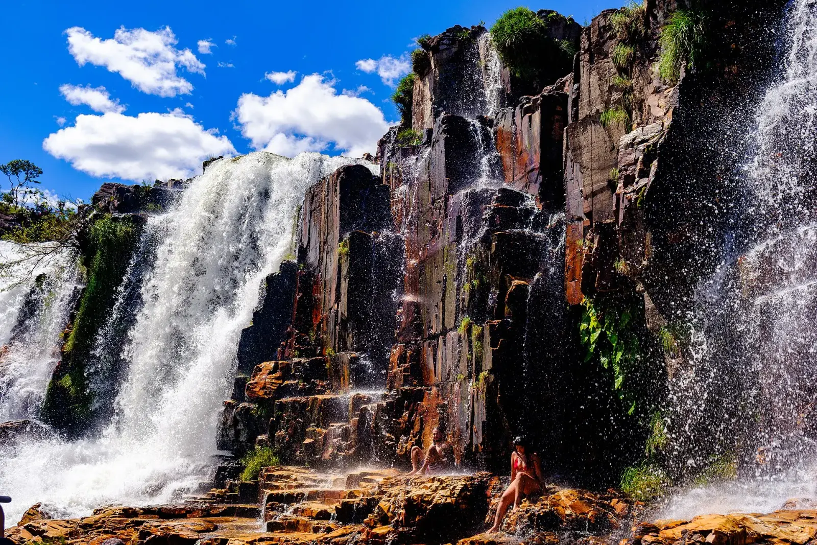 Waterfall pouring down red rock cliffs at Couros
