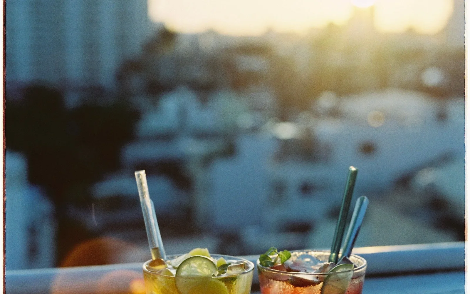 Two tall iced drinks on a rail against the last warm light of the day