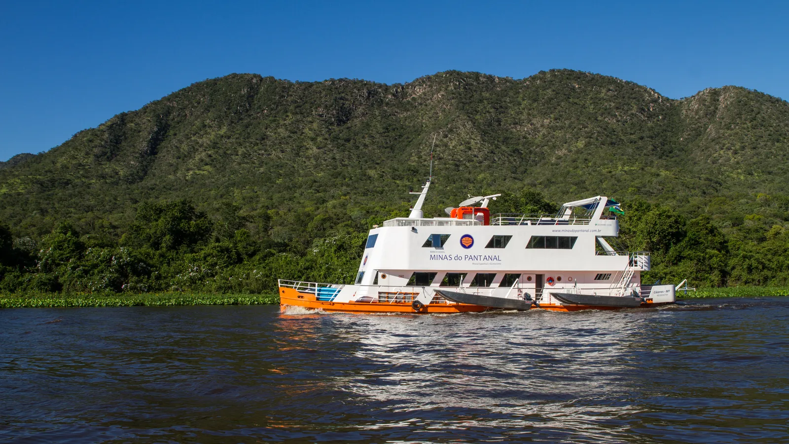 The small Pantanal expedition ship on the Rio Paraguai below forested hills