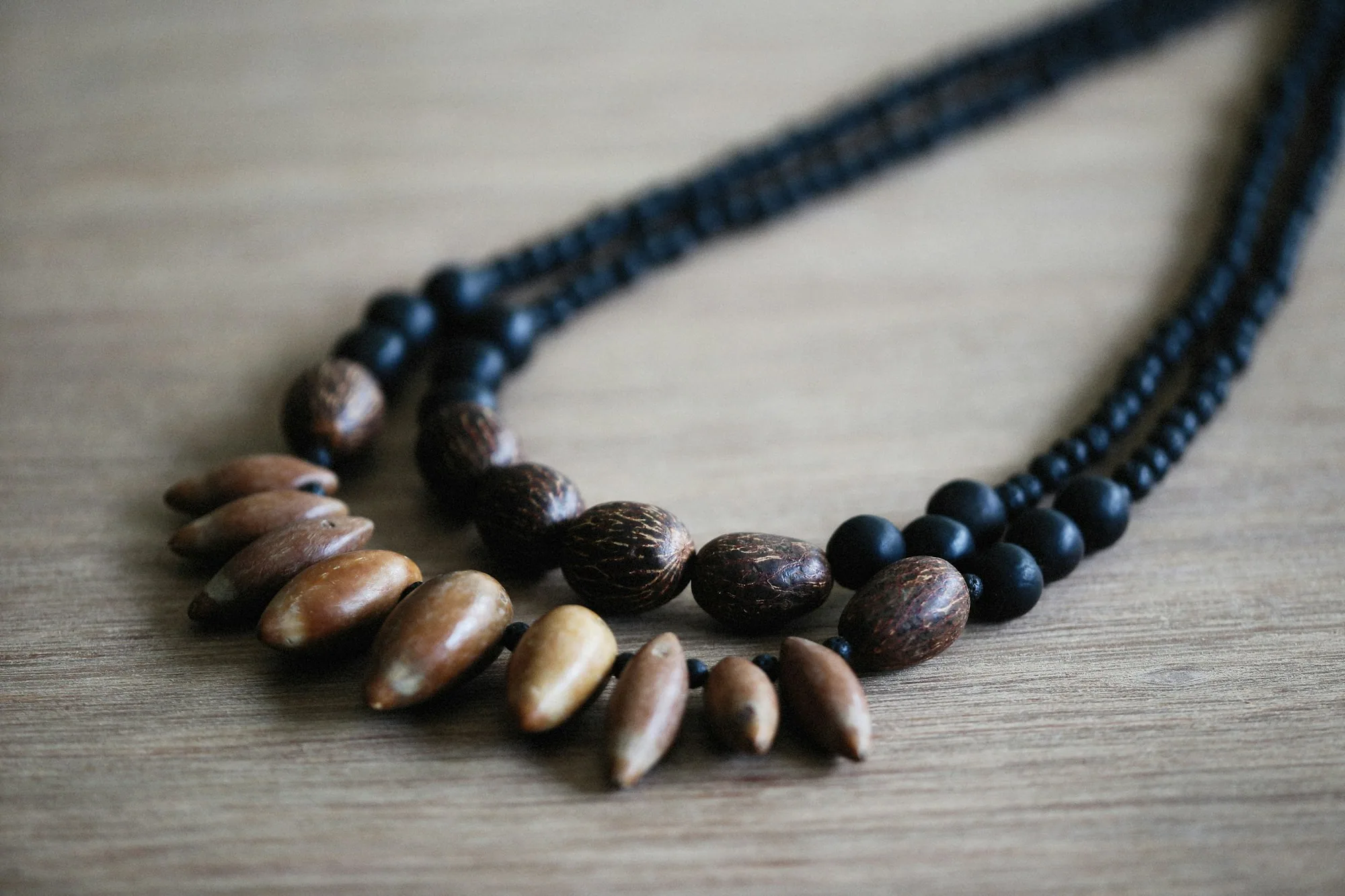 A handmade necklace strung from polished seeds and palm nuts