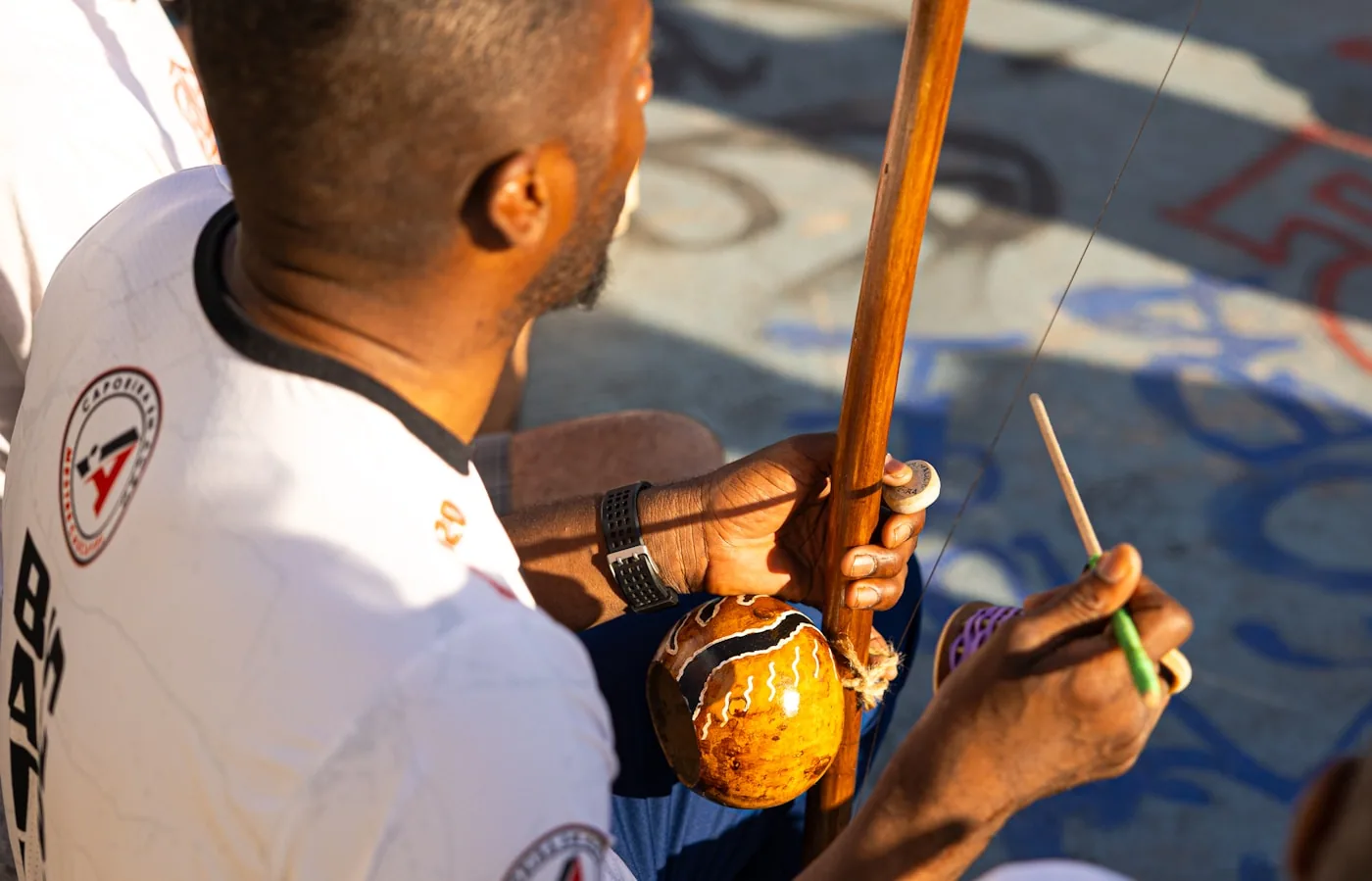 A capoeira musician playing a berimbau