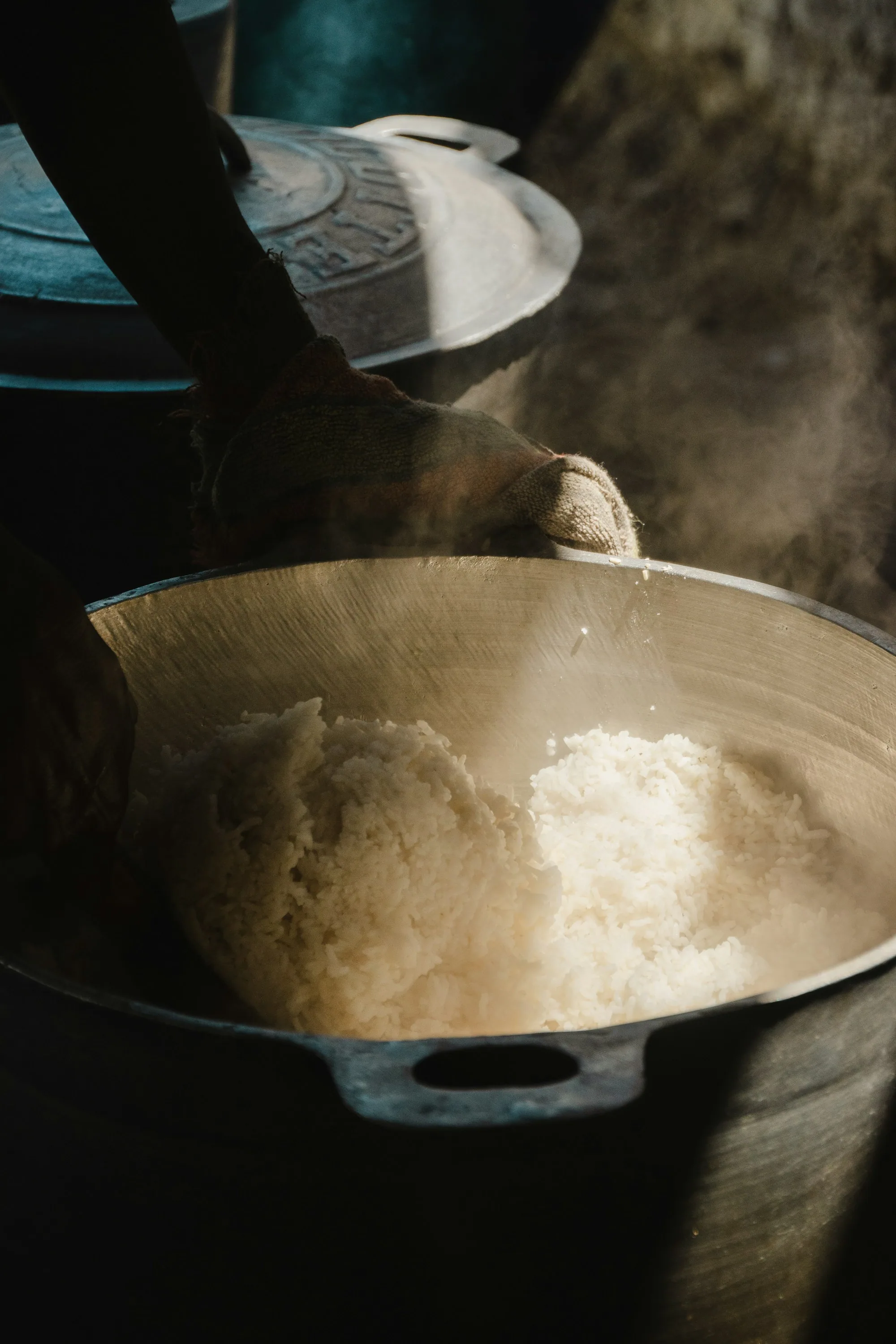Manioc worked by hand in a wide pan over the heat, steam rising
