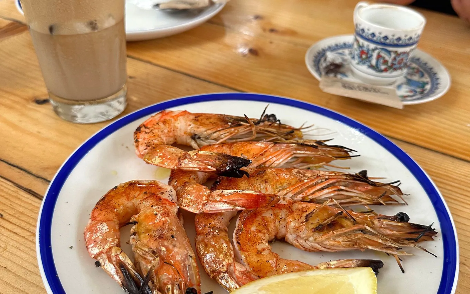 A plate of huge grilled prawns served at a rustic beach kitchen