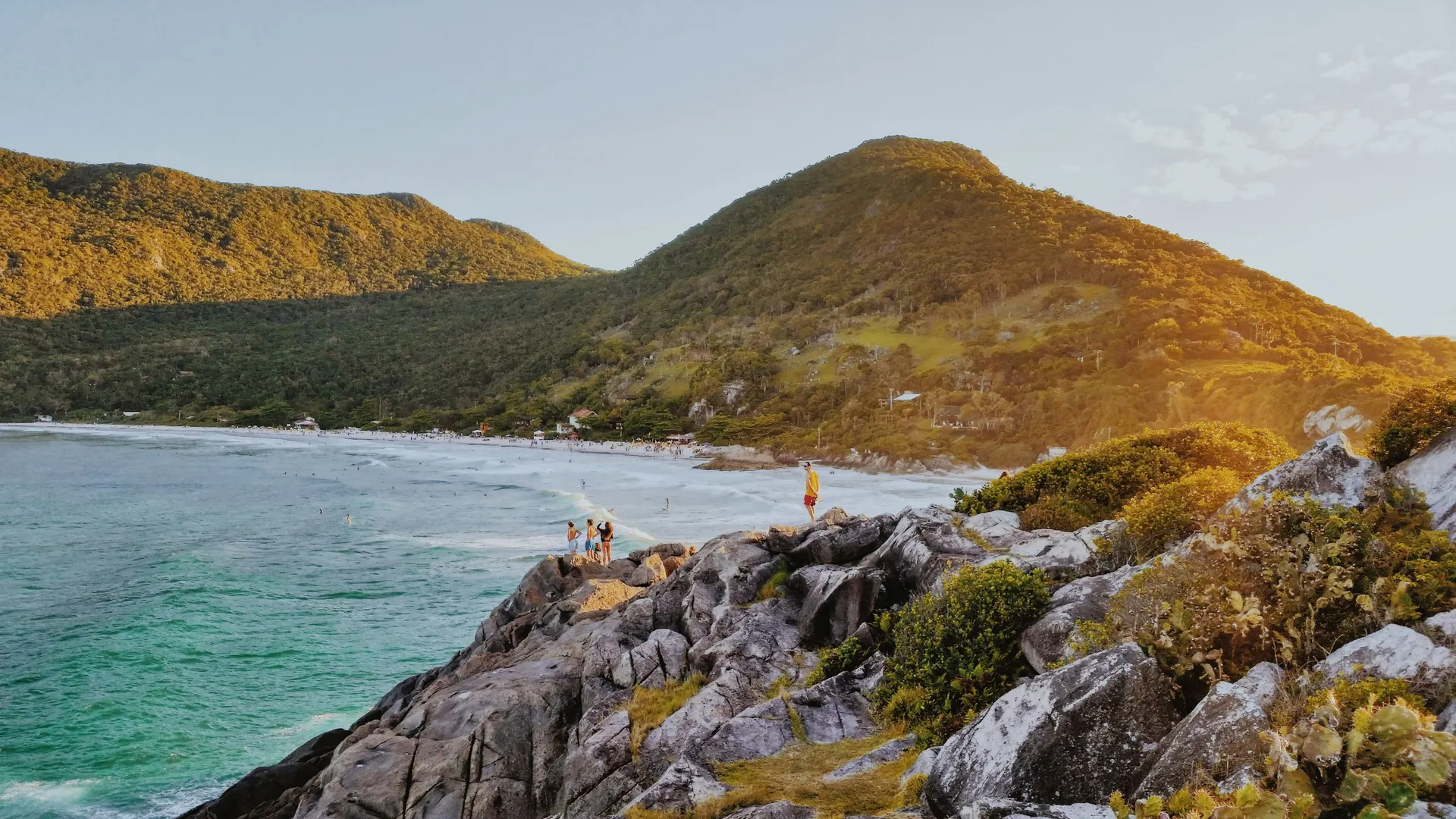 Wide aerial view over Florianópolis island: green coastline, beaches and blue ocean