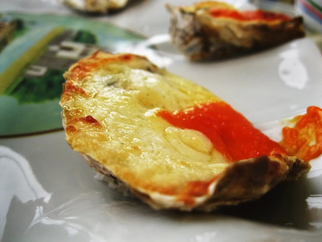 Fresh oysters on a plate at a waterside table in Ribeirão da Ilha, oyster farm in the channel behind