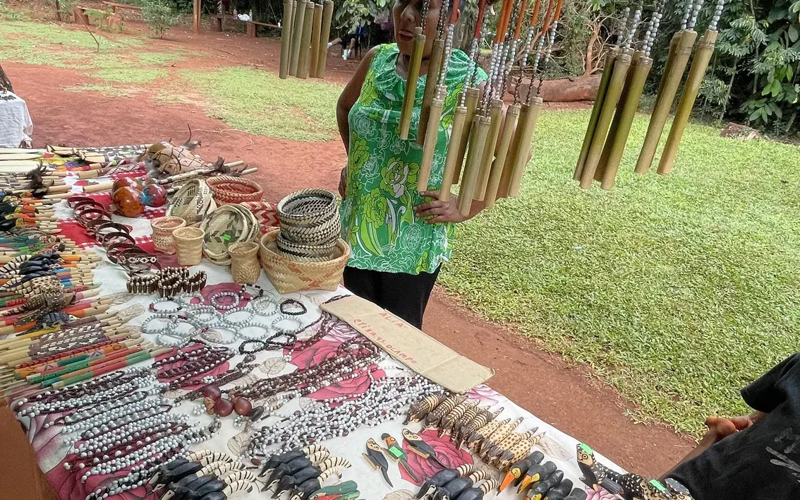 Guarani beadwork and carved bamboo laid out on a table at a community visit near Iguazú