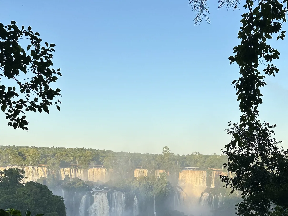 The Iguaçu Falls in soft early morning light, mist rising off the empty gorge