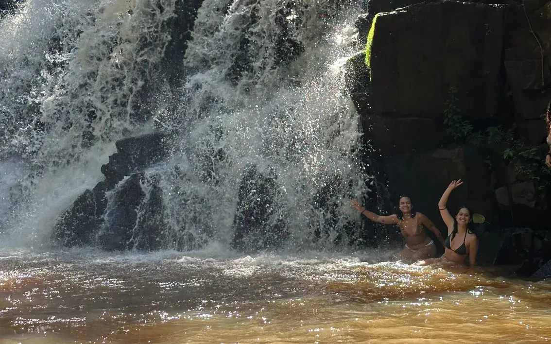 Swimmers in the pool beneath a small forest waterfall in the countryside around Foz do Iguaçu