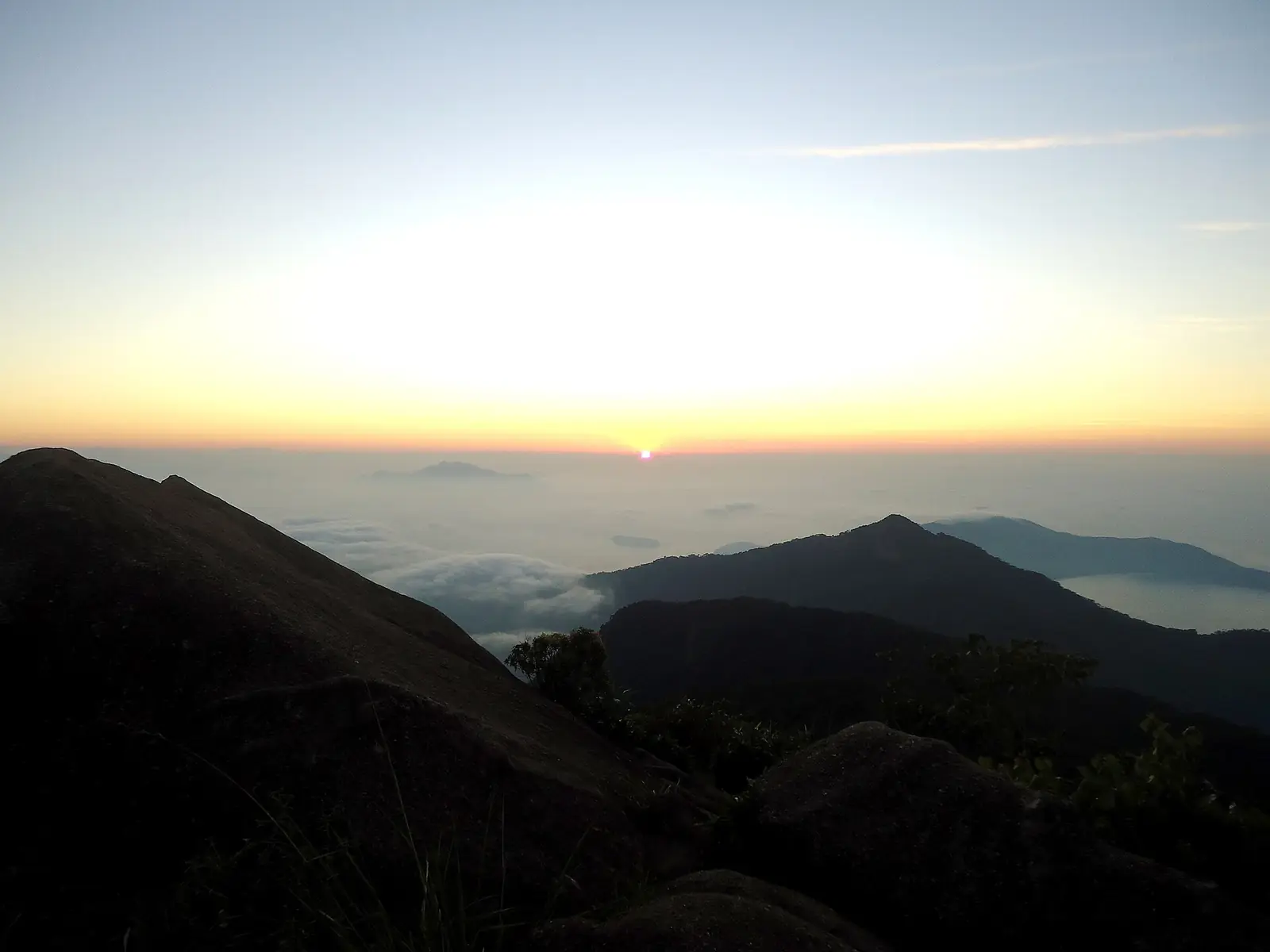 Sunrise view from the granite summit of Pico do Papagaio over the island and its bays