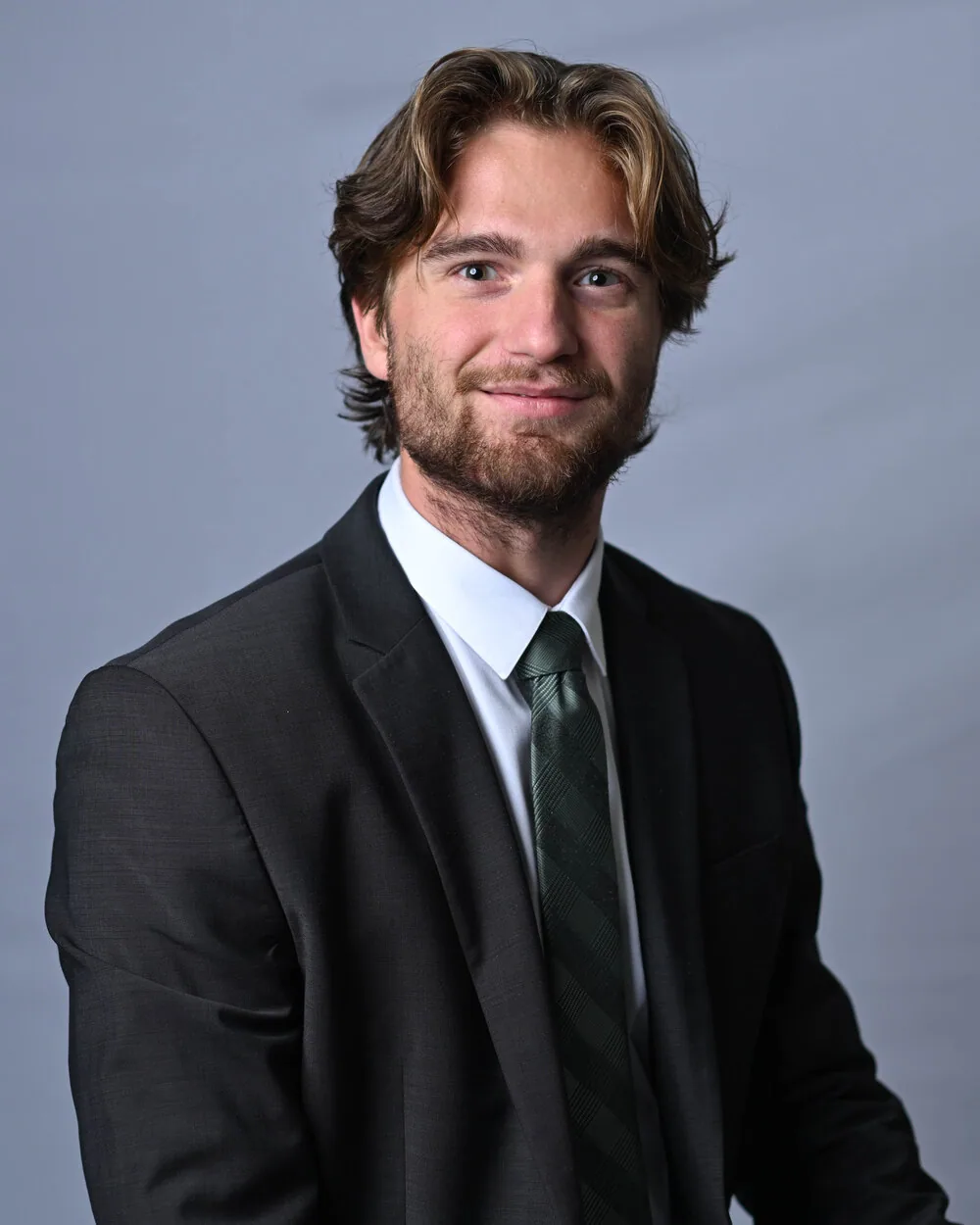 Logan, co-host of AuthenticBrazilTravel, in a dark suit